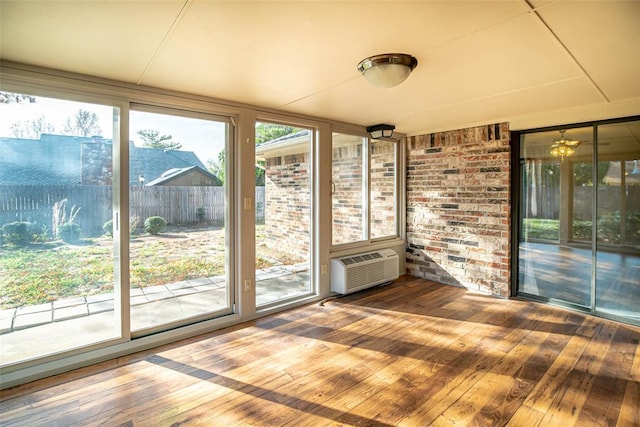 unfurnished sunroom with plenty of natural light and an AC wall unit