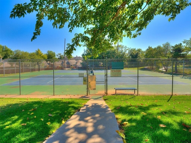 view of tennis court featuring a lawn