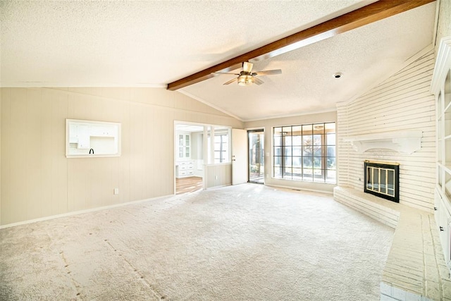 unfurnished living room featuring a fireplace, lofted ceiling with beams, a textured ceiling, and carpet