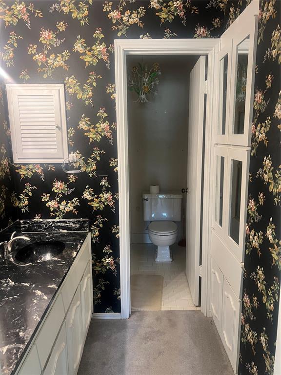 bathroom featuring tile patterned floors, vanity, and toilet