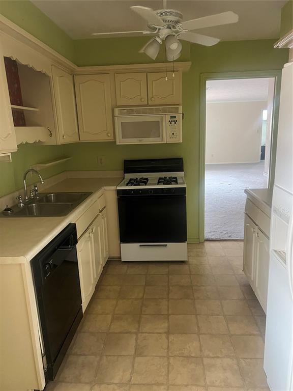 kitchen featuring ceiling fan, white appliances, sink, and light carpet