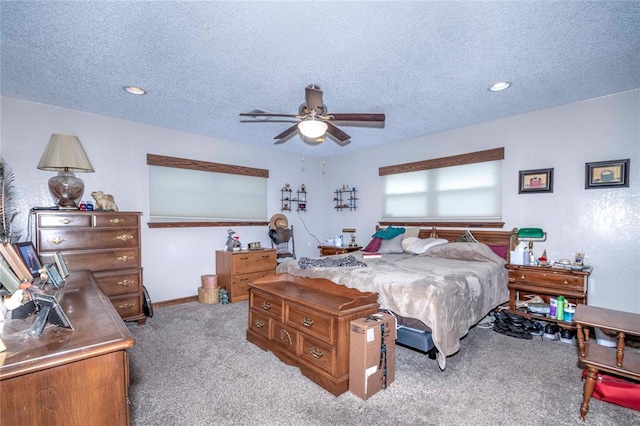 bedroom featuring ceiling fan, light colored carpet, and a textured ceiling