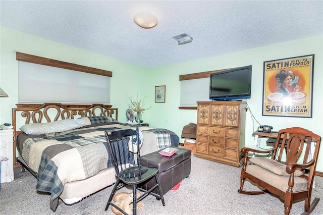 bedroom with light colored carpet and a textured ceiling