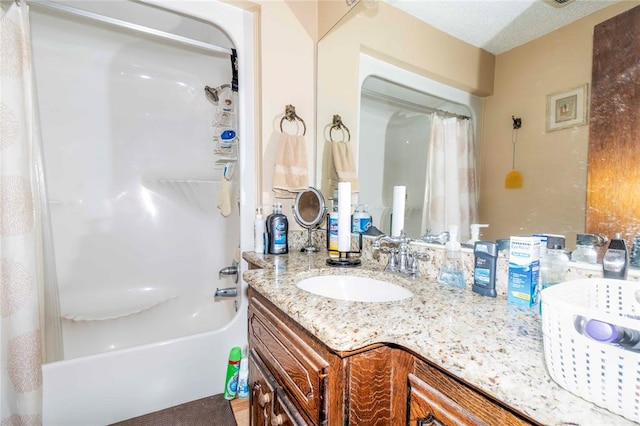 bathroom featuring a textured ceiling, vanity, and shower / bath combo