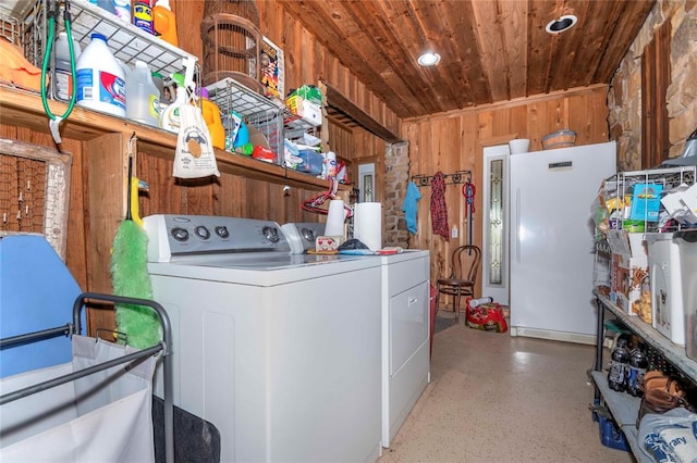 washroom featuring washing machine and dryer, wooden walls, and wood ceiling