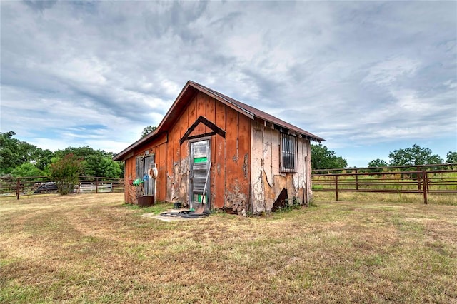 exterior space with a yard, a rural view, and an outdoor structure