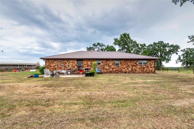 rear view of house featuring a patio and a lawn