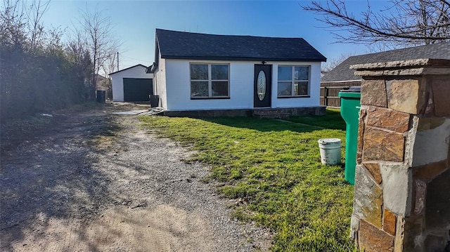 view of front of house featuring a front yard, a garage, and an outdoor structure