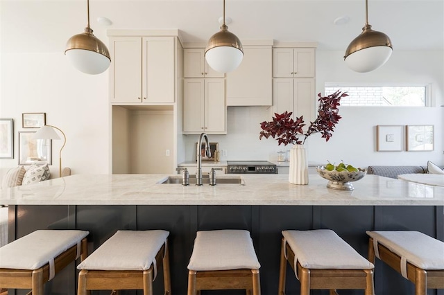 kitchen featuring a breakfast bar area, sink, and pendant lighting