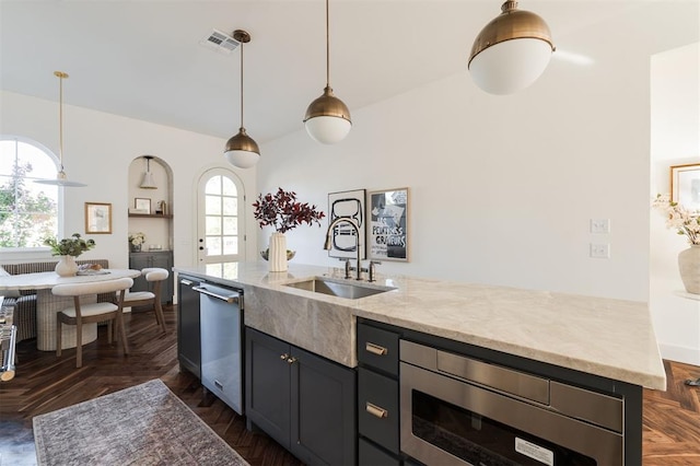 kitchen with decorative light fixtures, a center island with sink, plenty of natural light, and sink