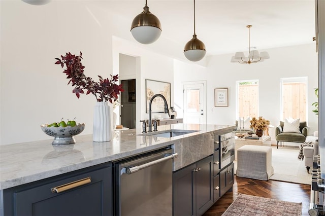 kitchen with appliances with stainless steel finishes, light stone counters, sink, a notable chandelier, and hanging light fixtures