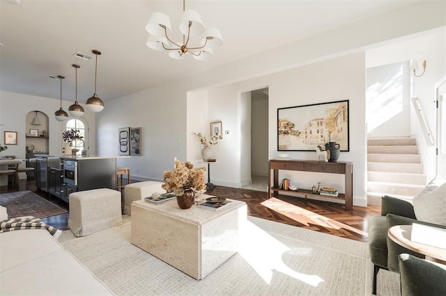 living room with parquet floors and an inviting chandelier