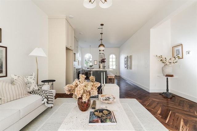 dining space featuring dark parquet floors and a chandelier