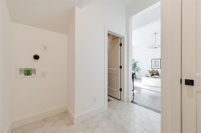 clothes washing area featuring washer hookup, hookup for an electric dryer, light tile patterned flooring, and an inviting chandelier