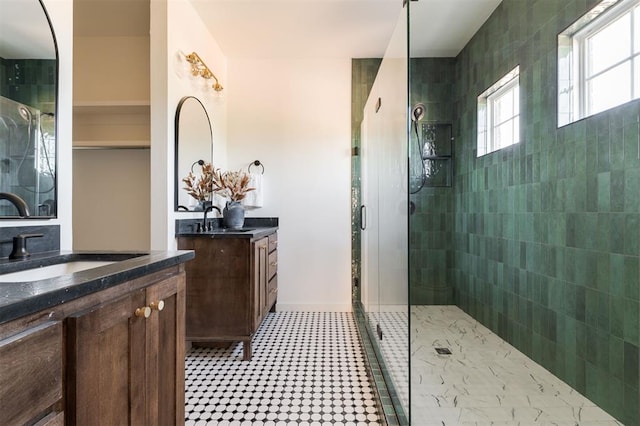 bathroom with a tile shower and vanity