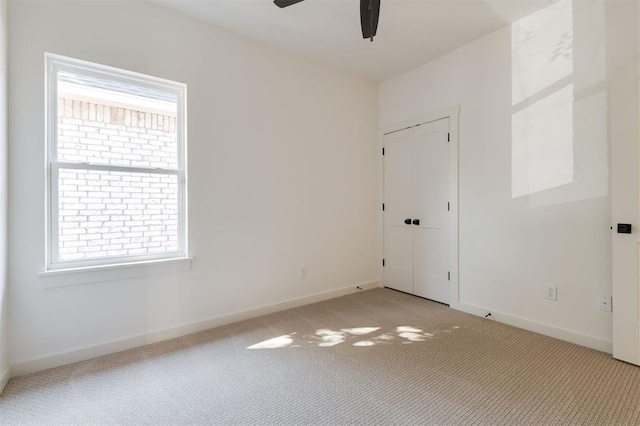 carpeted empty room with ceiling fan and a healthy amount of sunlight