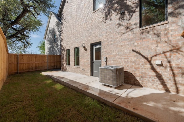 view of side of property with a yard and central AC