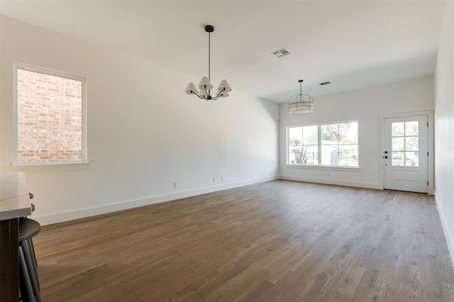 unfurnished living room featuring a chandelier and wood-type flooring