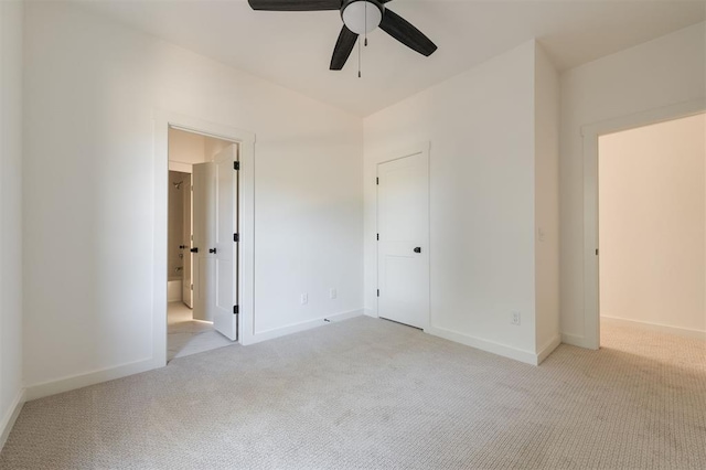 unfurnished bedroom featuring light carpet, connected bathroom, and ceiling fan