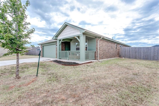 single story home featuring a front yard, a porch, and a garage