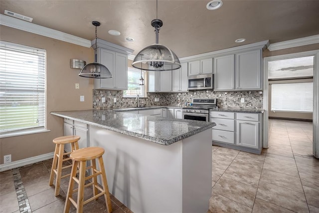 kitchen with light stone countertops, tasteful backsplash, ornamental molding, stainless steel appliances, and decorative light fixtures