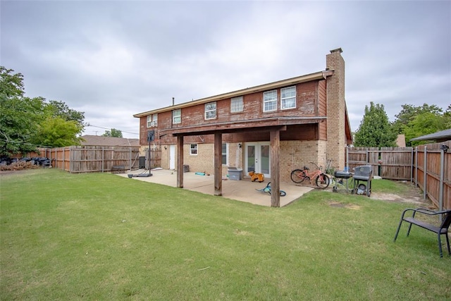 back of house with french doors, a patio area, and a lawn