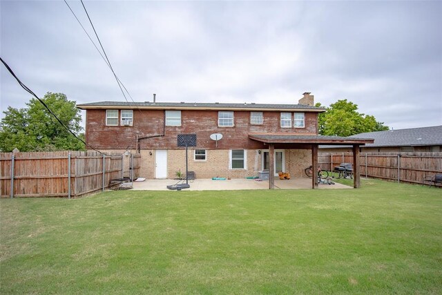 rear view of property featuring a yard and a patio area