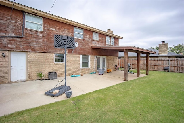 rear view of house featuring a lawn and a patio area