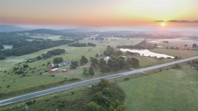 aerial view at dusk featuring a rural view and a water and mountain view