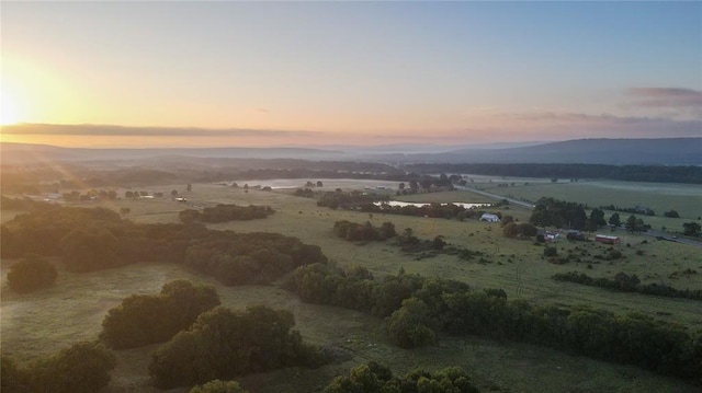 aerial view at dusk with a rural view and a water and mountain view