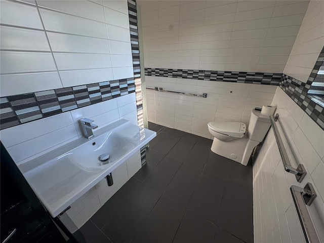 bathroom featuring tile patterned flooring, toilet, and tile walls