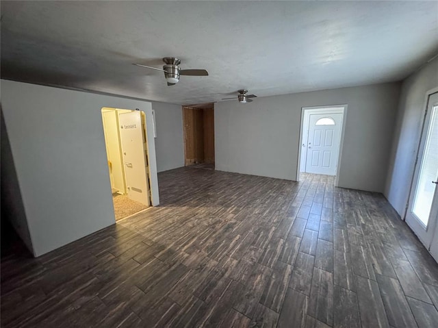 unfurnished living room with ceiling fan and dark hardwood / wood-style flooring