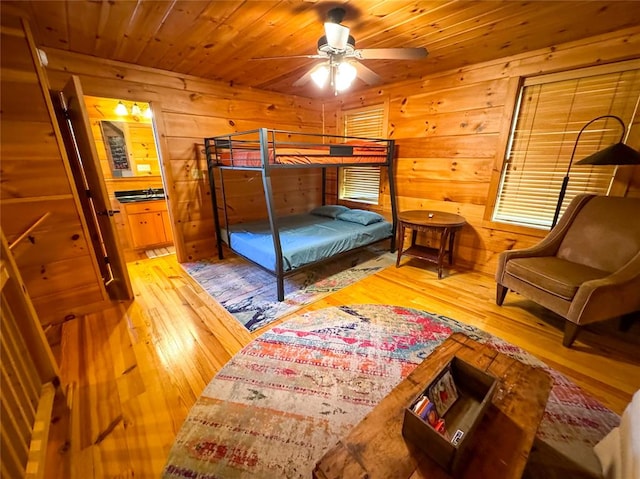 bedroom featuring hardwood / wood-style floors, ceiling fan, wooden walls, and wood ceiling