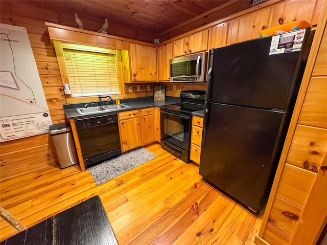 kitchen with wood walls, light wood-type flooring, wooden ceiling, and black appliances