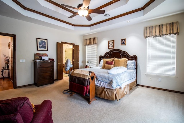 carpeted bedroom with a raised ceiling, ceiling fan, and ornamental molding