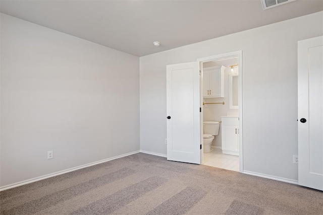 unfurnished bedroom featuring connected bathroom and light colored carpet