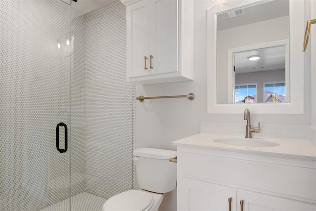 bathroom with vanity, toilet, and a shower with shower door