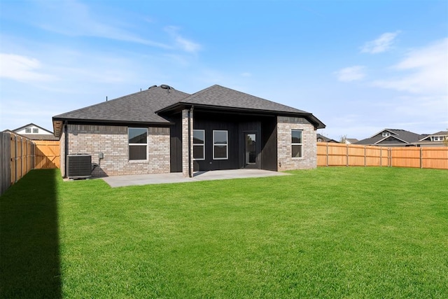 back of house featuring cooling unit, a patio area, and a yard