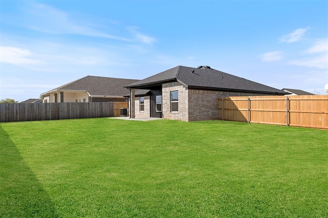 rear view of house with a yard and central AC unit