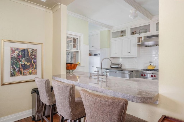 kitchen featuring range hood, kitchen peninsula, crown molding, decorative backsplash, and white cabinets