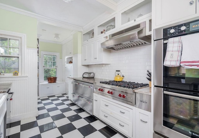 kitchen featuring white cabinets, backsplash, stainless steel appliances, and crown molding