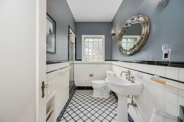 bathroom featuring sink, tile walls, and toilet