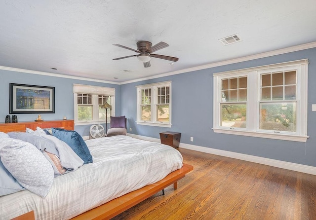 bedroom featuring hardwood / wood-style flooring, ceiling fan, and ornamental molding