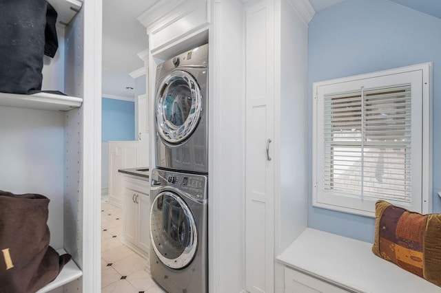 clothes washing area featuring crown molding and stacked washing maching and dryer