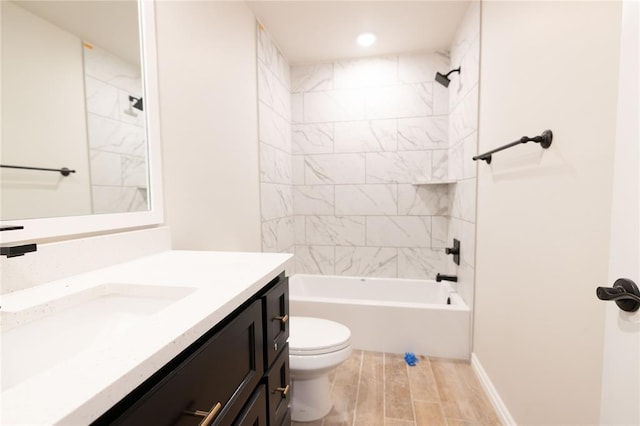 full bathroom featuring tiled shower / bath, vanity, and toilet