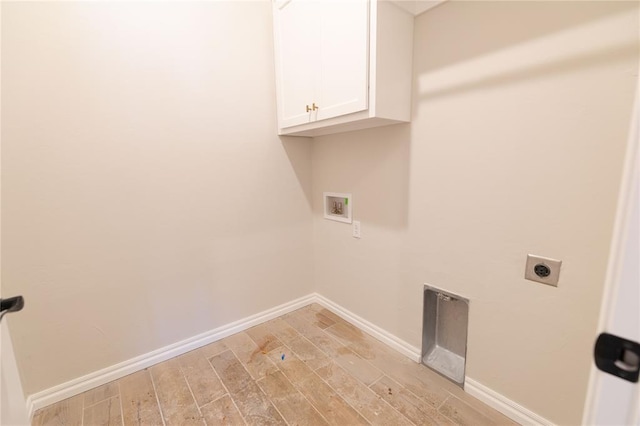 laundry room featuring electric dryer hookup, hookup for a washing machine, cabinets, and light wood-type flooring