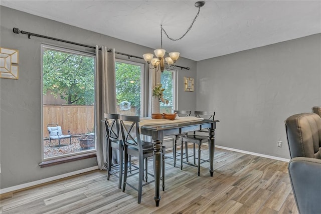 dining space featuring wood-type flooring and a notable chandelier