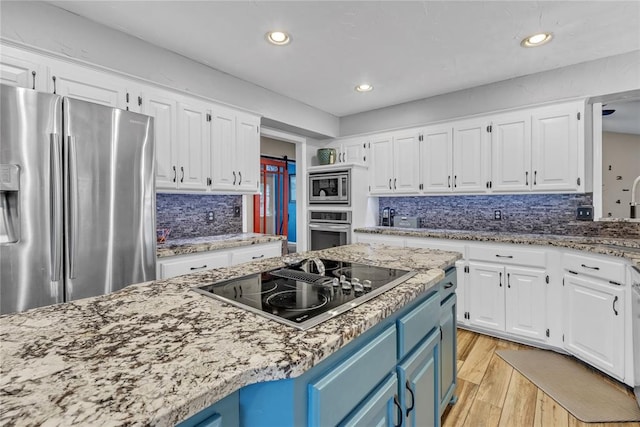 kitchen with blue cabinetry, stainless steel appliances, light hardwood / wood-style flooring, backsplash, and white cabinets