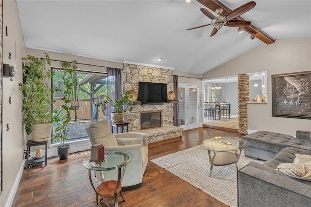 living room featuring lofted ceiling with beams, a stone fireplace, ceiling fan, and dark wood-type flooring