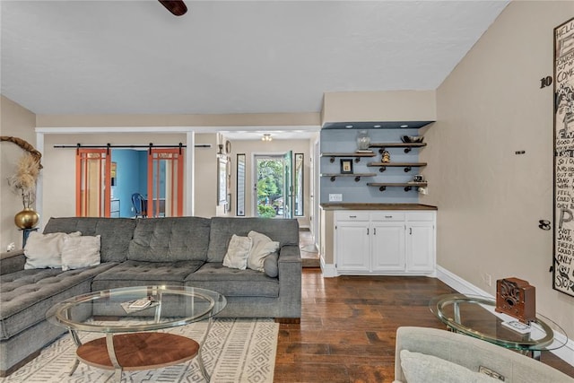 living room featuring a barn door and dark hardwood / wood-style floors